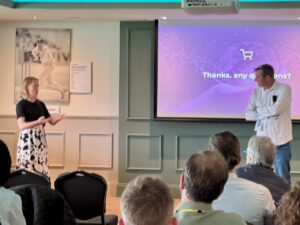 Presenter Charlotte Kiddle taking questions with conference chair AJ Johnson in front of an audience of people.